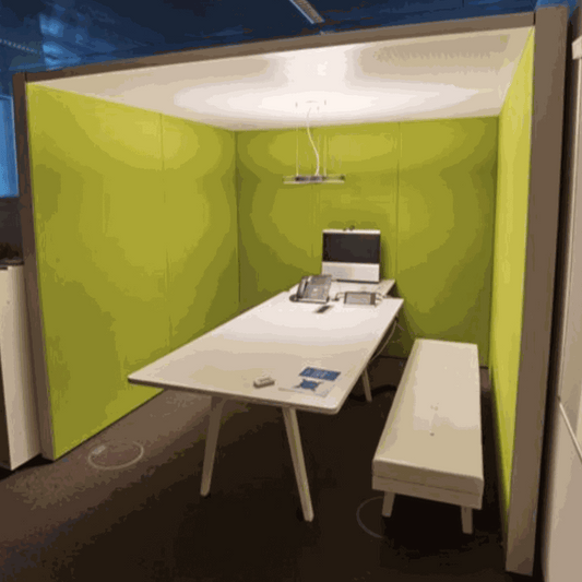 Vitra ThinkTank SilentWall team workspace with green fabric walls, white table, bench, and overhead light