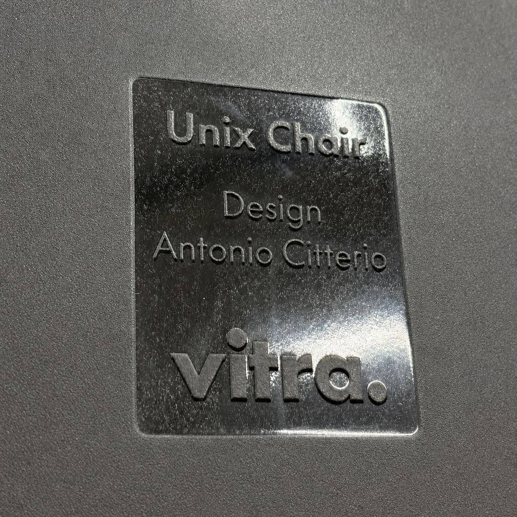 Schwarzes Vitra Unix Chair Typenschild mit eingeprägtem Design von Antonio Citterio auf schwarzem Mesh-Bezug.