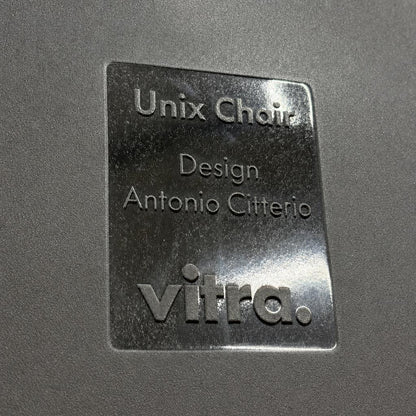 Schwarzes Vitra Unix Chair Typenschild mit eingeprägtem Design von Antonio Citterio auf schwarzem Mesh-Bezug.