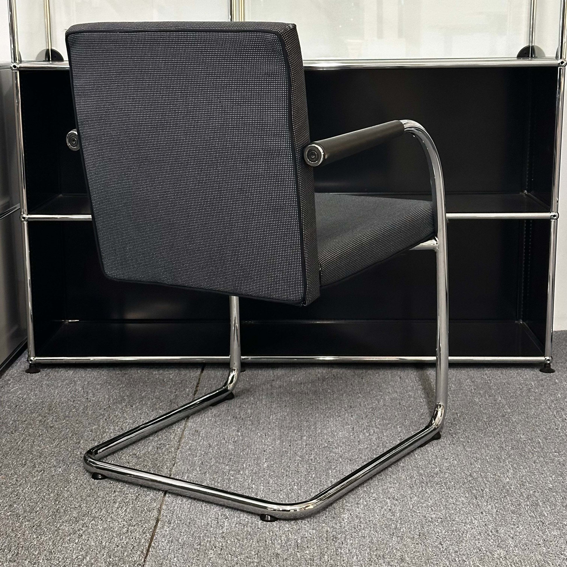 Black and grey Vitra Visasoft cantilever visitor chair with chrome frame and fabric upholstery in modern office setting