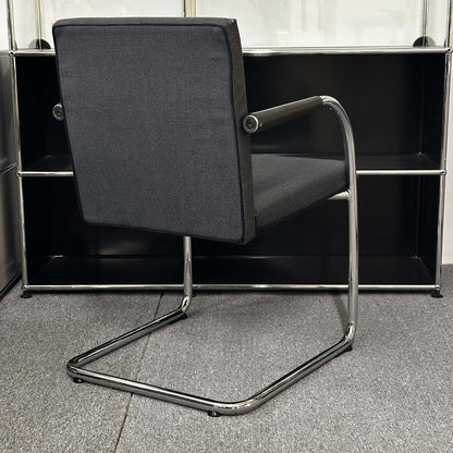 Black and grey Vitra Visasoft cantilever visitor chair with chrome frame and fabric upholstery in modern office setting
