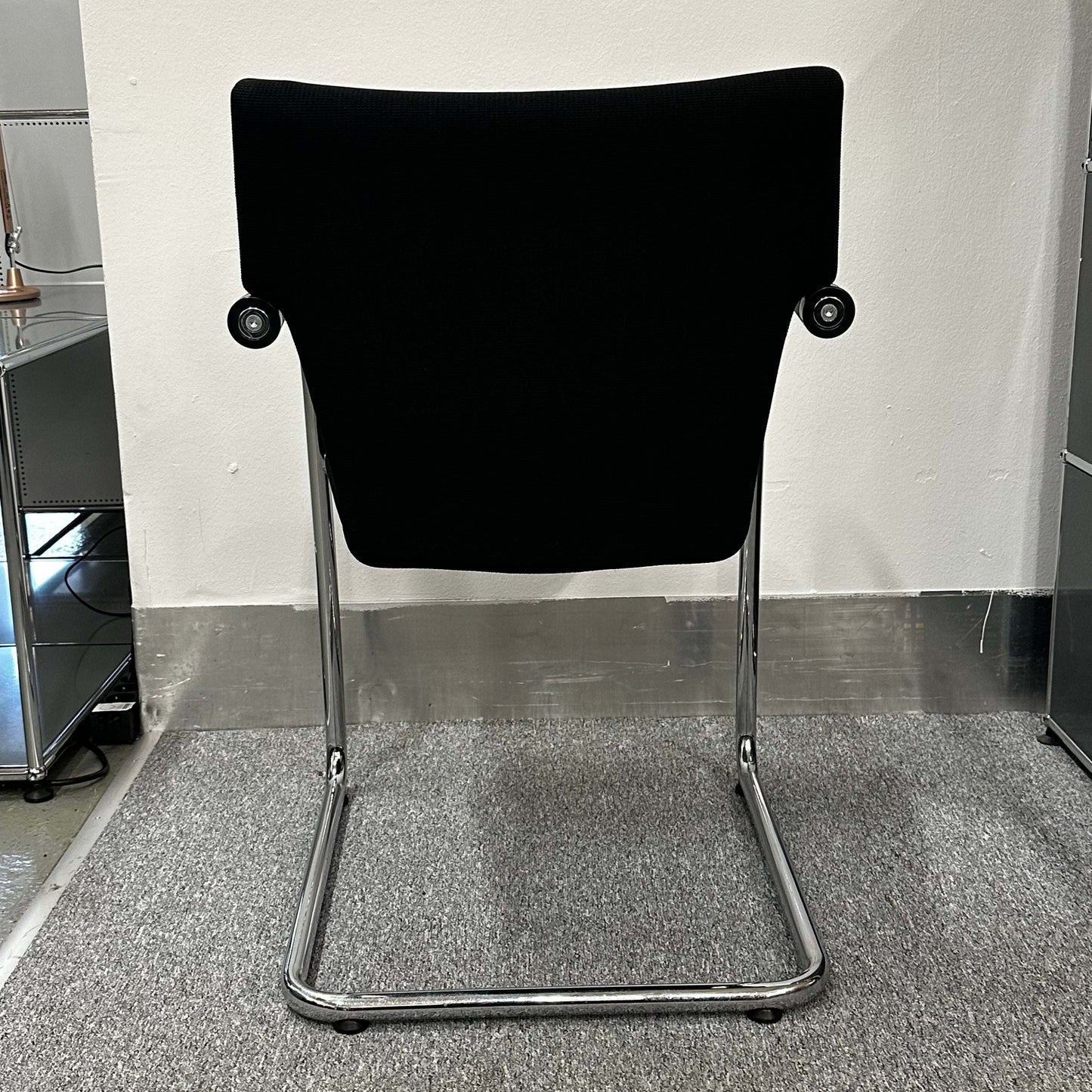 Black Vitra Visastripe conference chair with chrome cantilever frame seen from the back