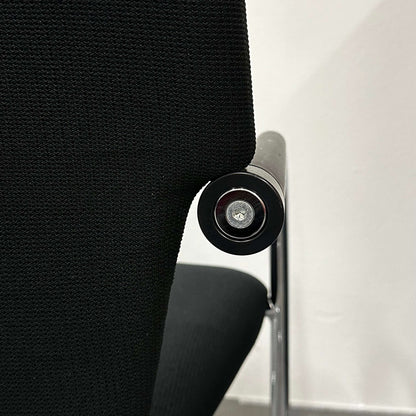 Close-up of black Vitra Visastripe conference chair with modern ergonomic design and metallic armrest detail