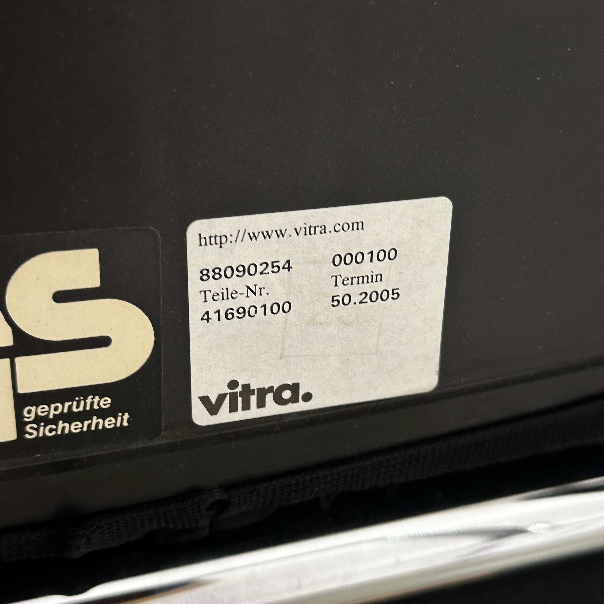 Close-up of Vitra Visastripe black conference chair label showing model and safety certification details