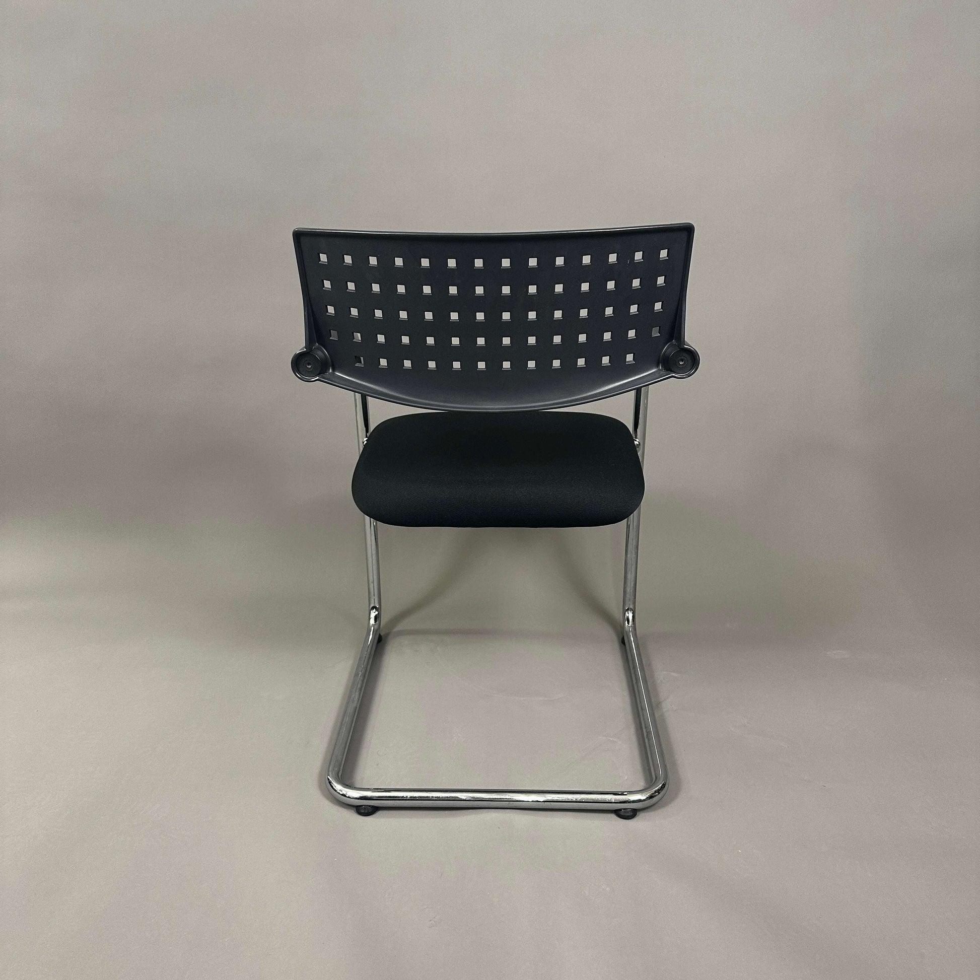 Vitra Visavis 1 black stackable chair with chrome frame and perforated backrest