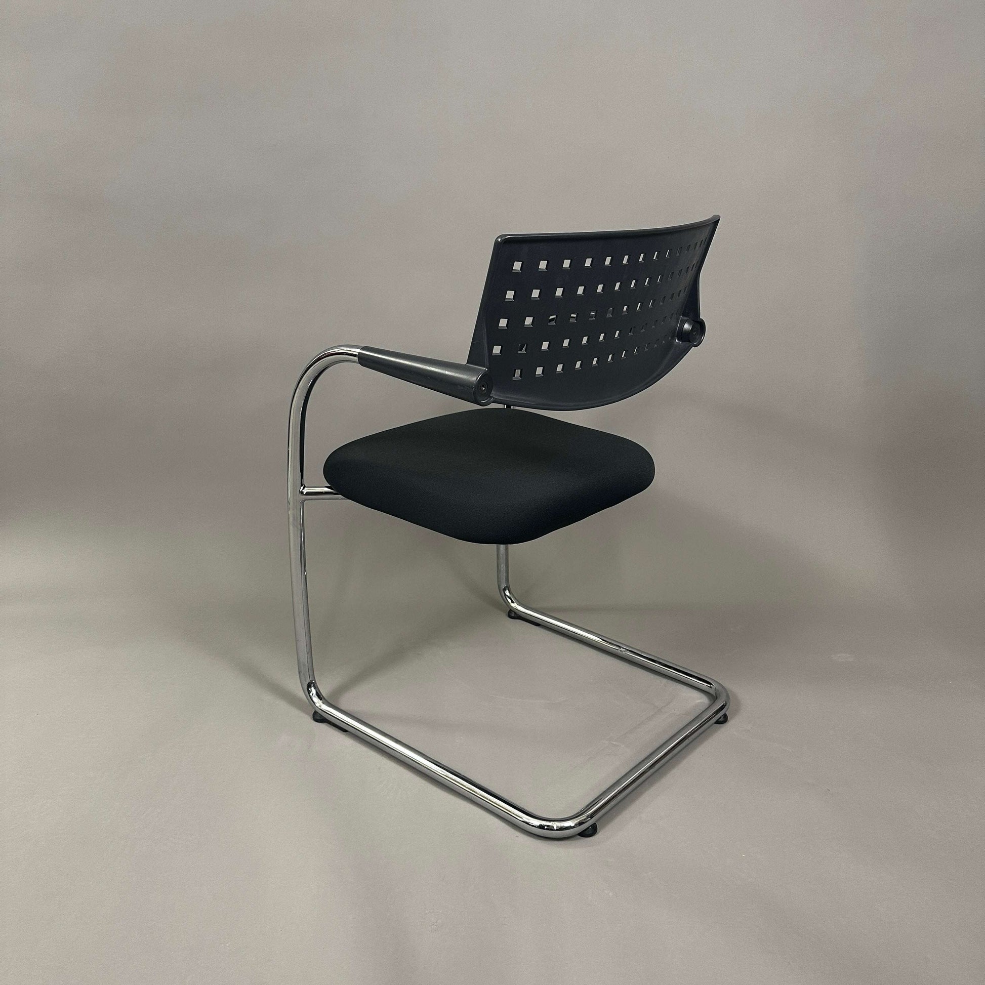 Vitra Visavis 1 black stackable chair with chrome frame and black cushioned seat
