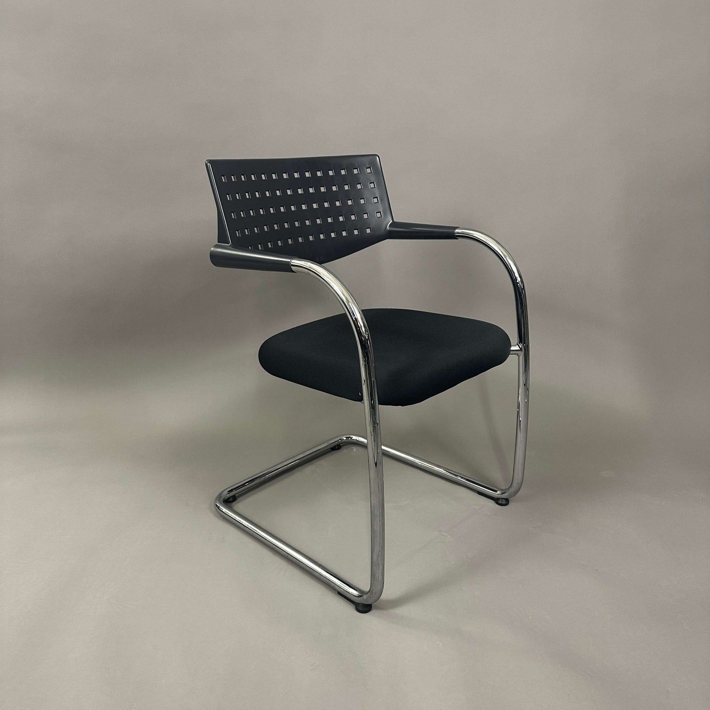 Vitra Visavis 1 black stackable chair with chrome frame and perforated backrest