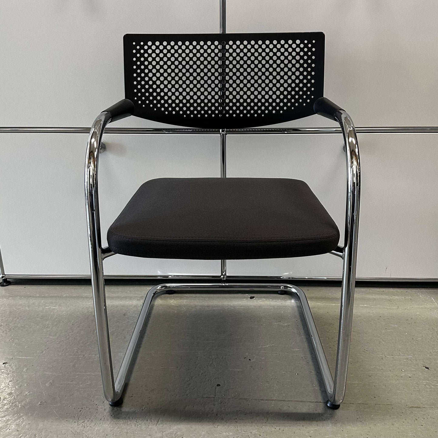 Vitra Visavis 2 chair with dark grey fabric seat, black perforated plastic backrest, and chrome cantilever frame