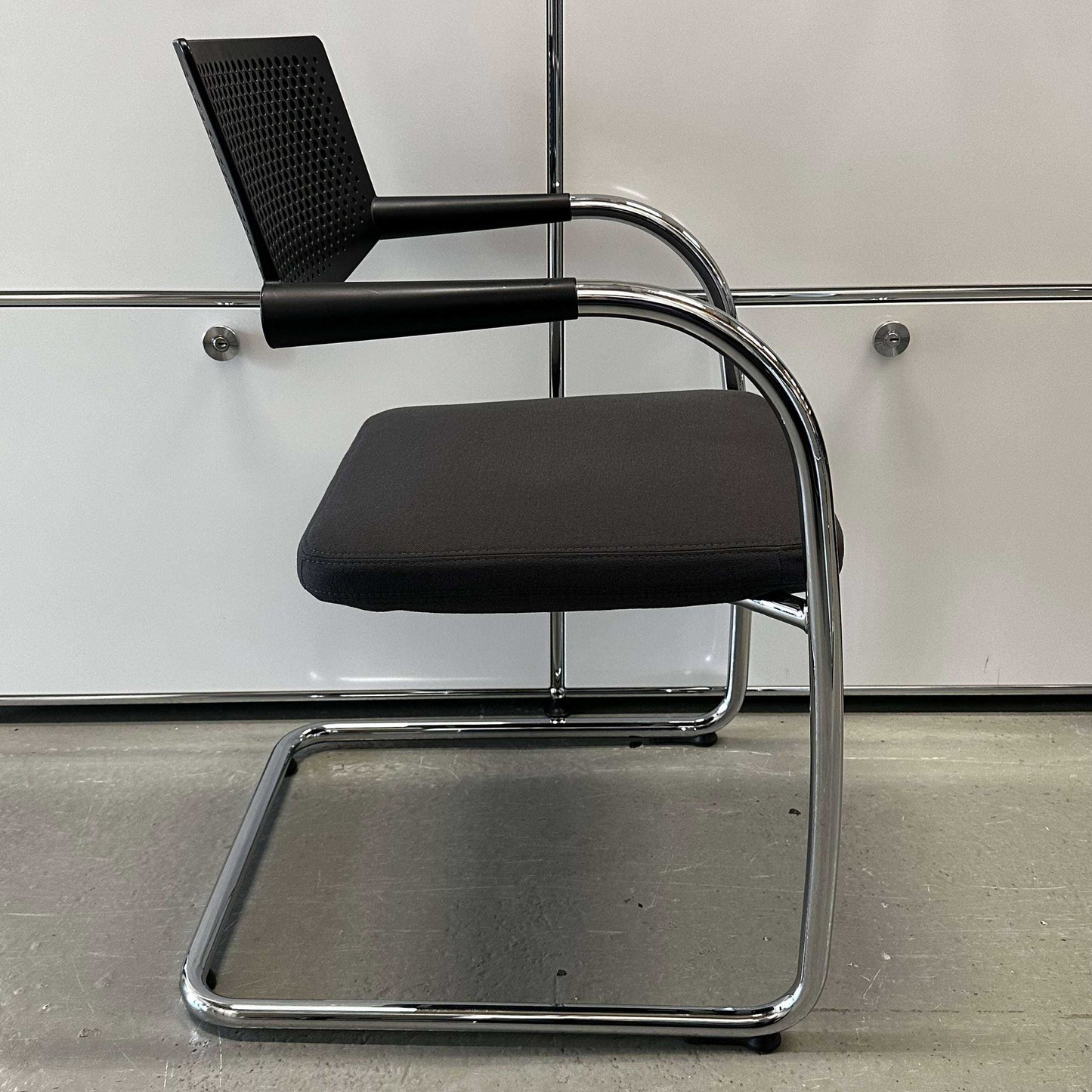 Vitra Visavis 2 chair with dark grey fabric seat, black plastic backrest, and chrome frame