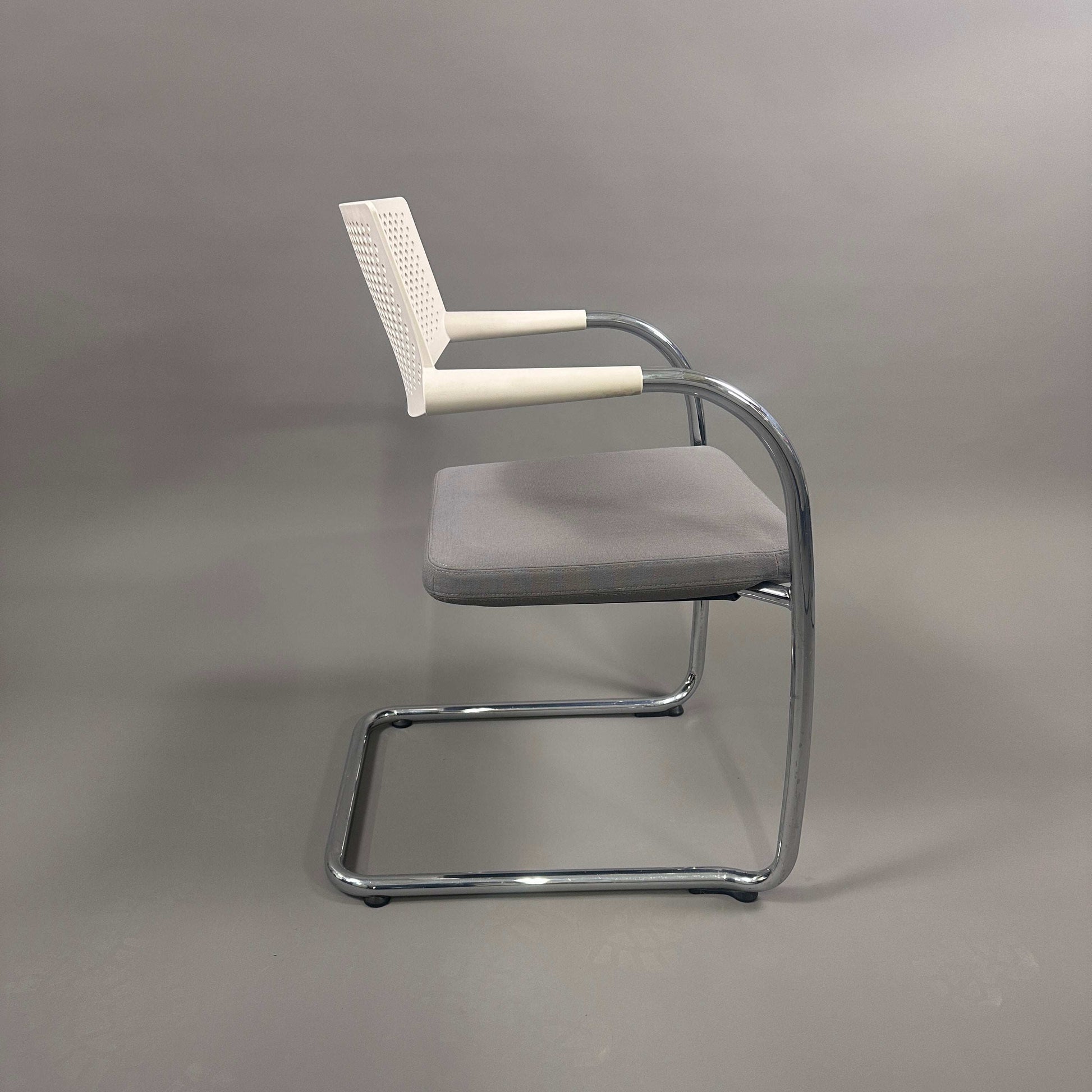 Vitra Visavis 2 chair with gray upholstered seat, white plastic backrest, and chrome frame in side view