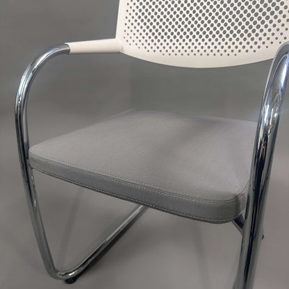 Vitra Visavis 2 chair with grey padded seat, white perforated plastic backrest, and chrome frame