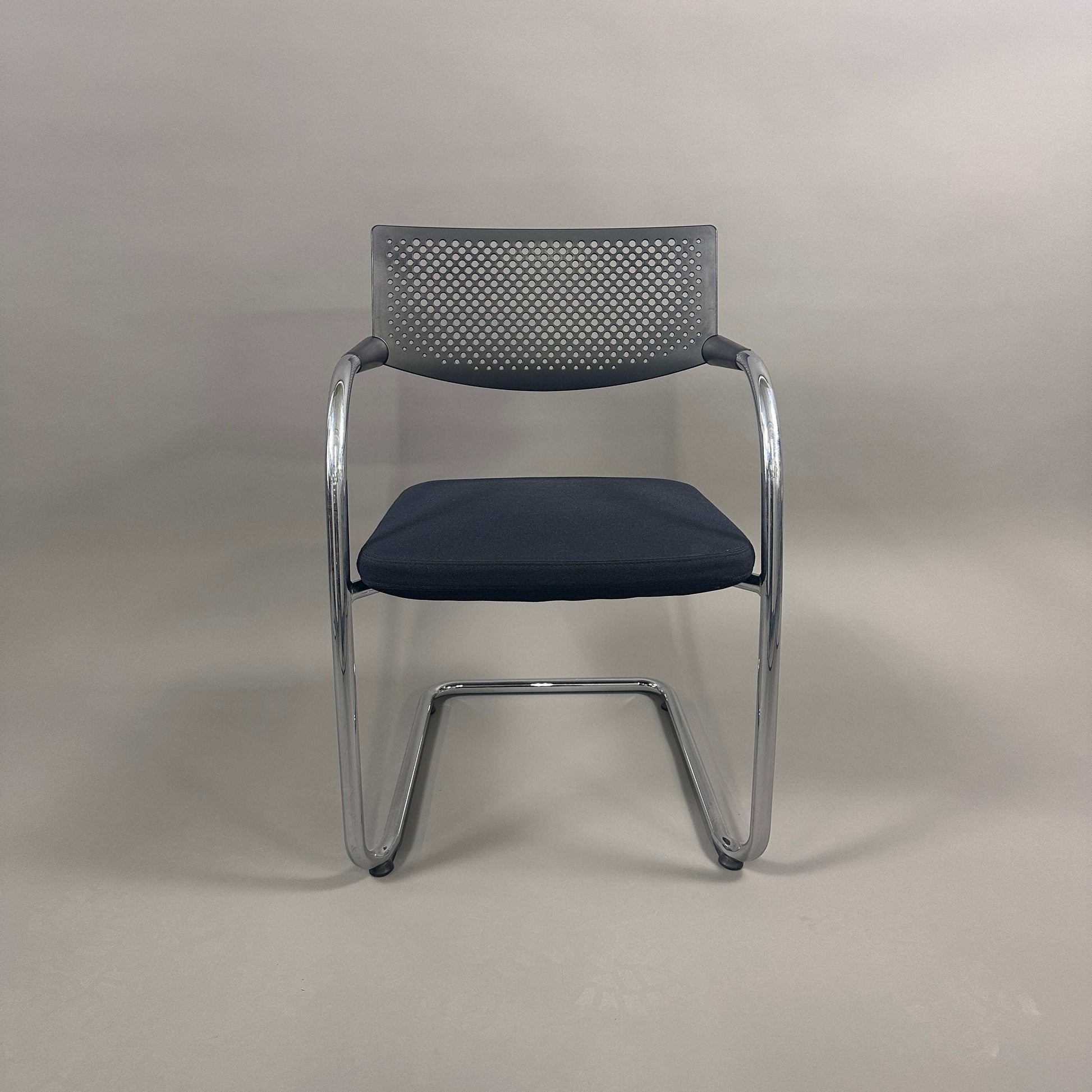 Vitra Visavis 2 black visitor chair with black fabric seat, perforated black plastic backrest, and chrome frame