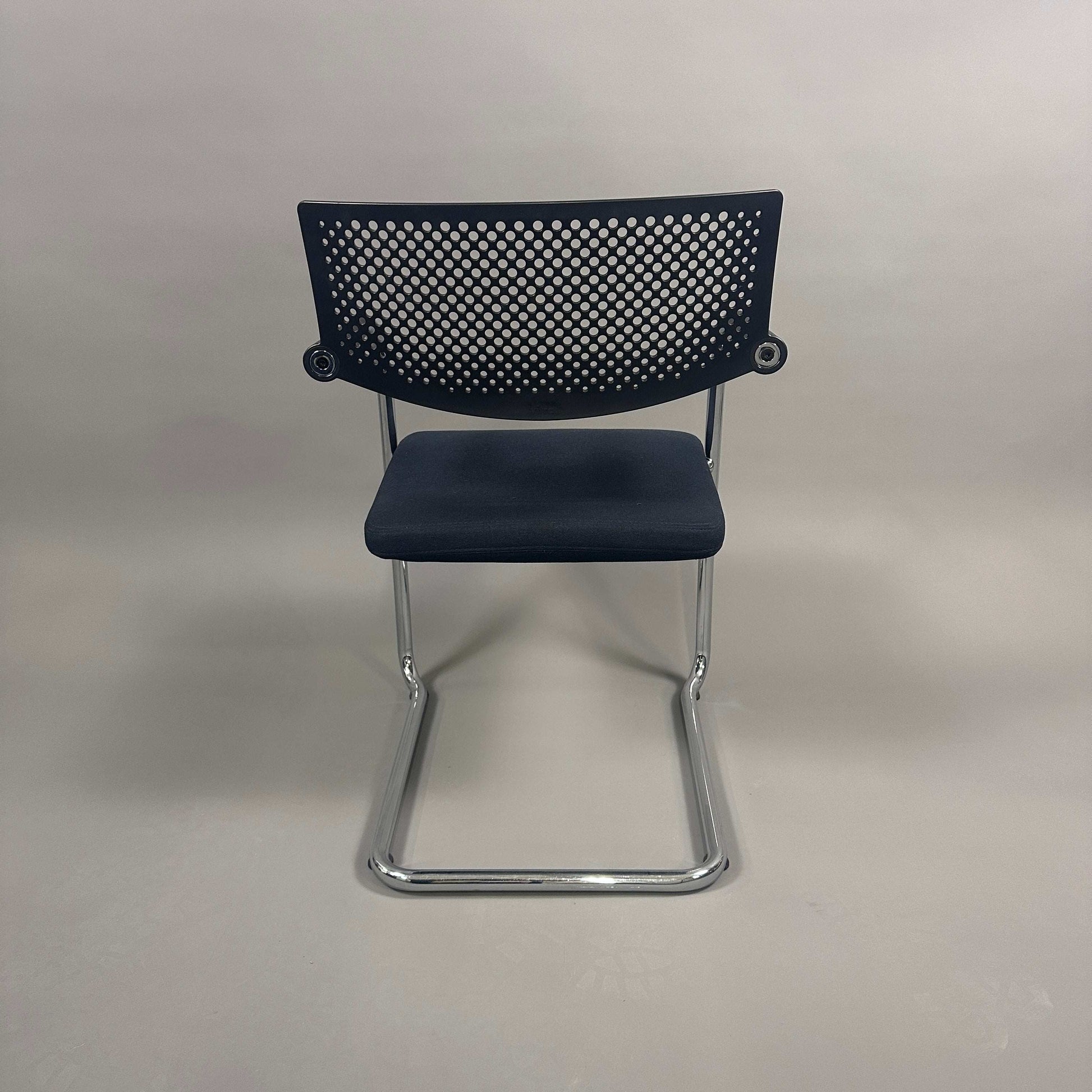 Vitra Visavis 2 black visitor chair with black fabric seat, perforated black plastic backrest, and chrome frame