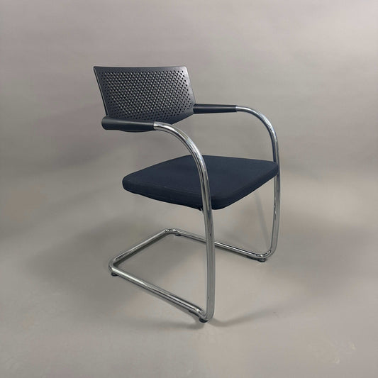 Vitra Visavis 2 black visitor chair with black fabric seat, perforated black plastic backrest, and chrome frame