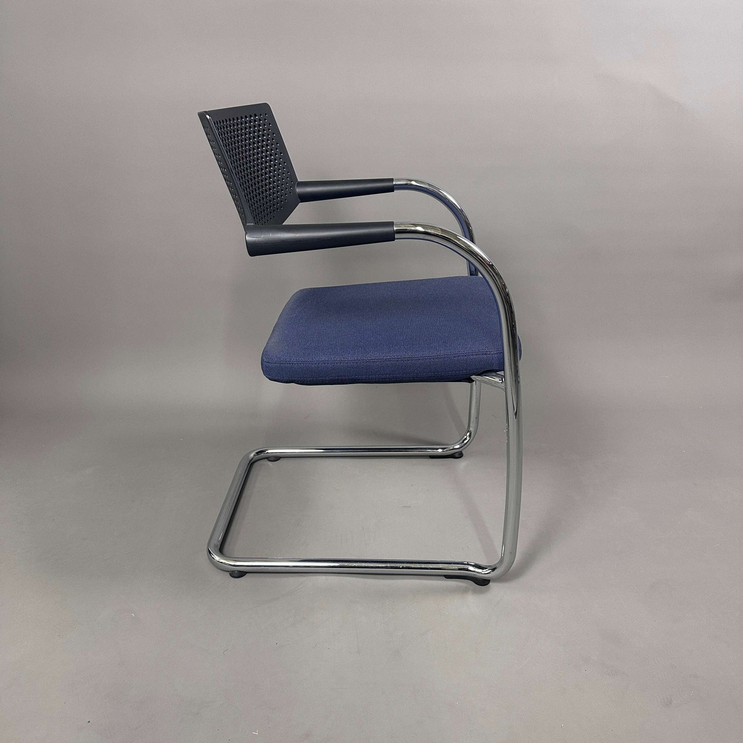 Vitra Visavis 2 Stuhl mit blau gepolsterter Sitzfläche, schwarzer Kunststoffrückenlehne und chromgestell, stapelbar