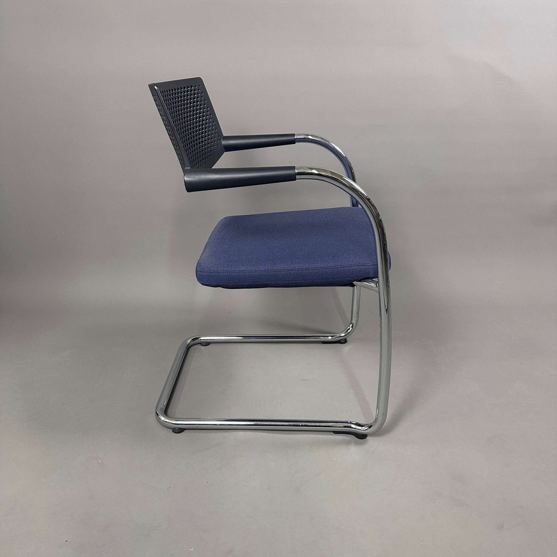 Vitra Visavis 2 Stuhl mit blau gepolsterter Sitzfläche, schwarzer Kunststoffrückenlehne und chromgestell, stapelbar