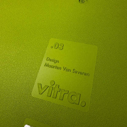 Close-up of Vitra .03 Besucherstuhl avocado chair label with textured plastic surface and embossed designer name Maarten Van Severen.