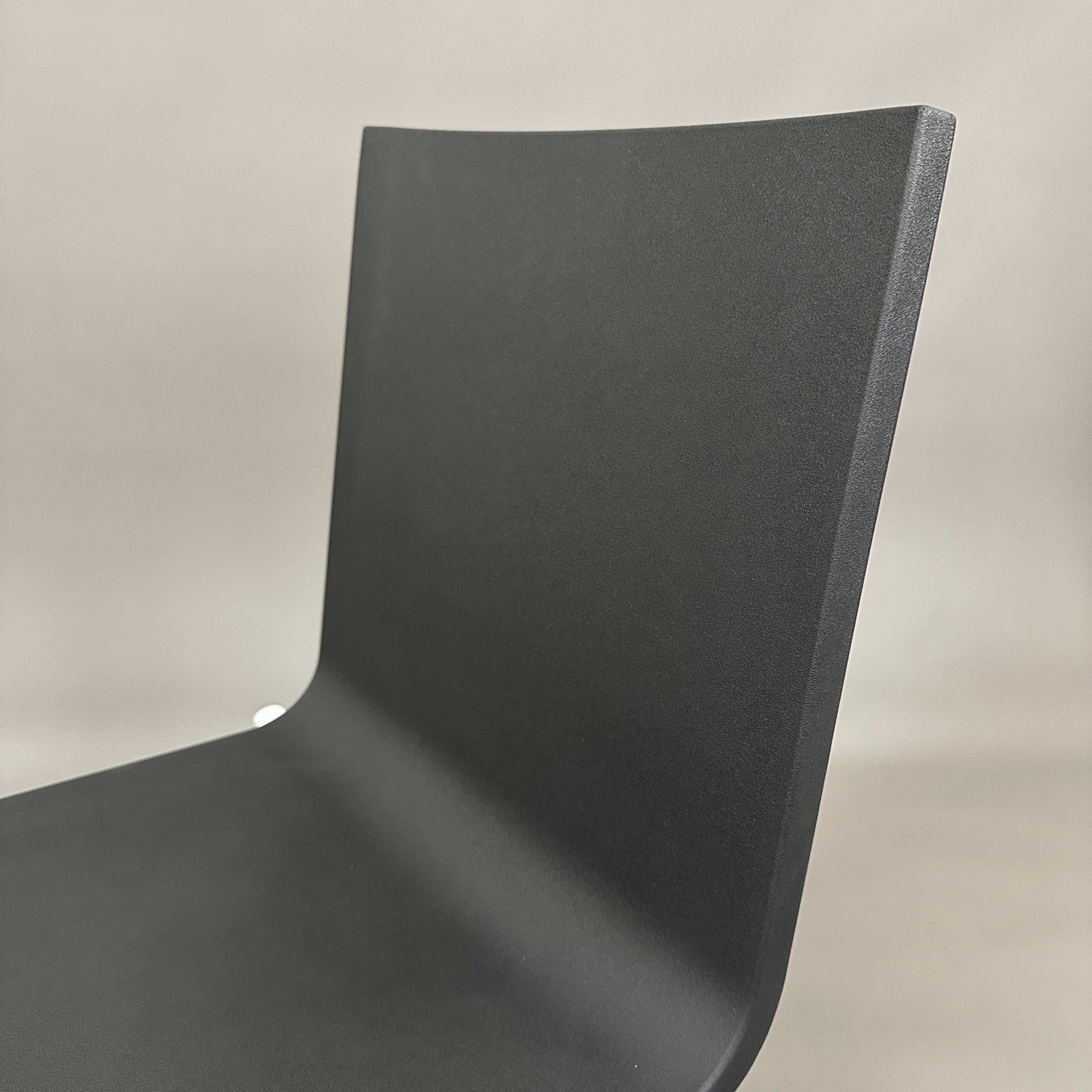 Close-up of black Vitra .03 Besucherstuhl chair with matte silver aluminum frame and smooth plastic seat shell