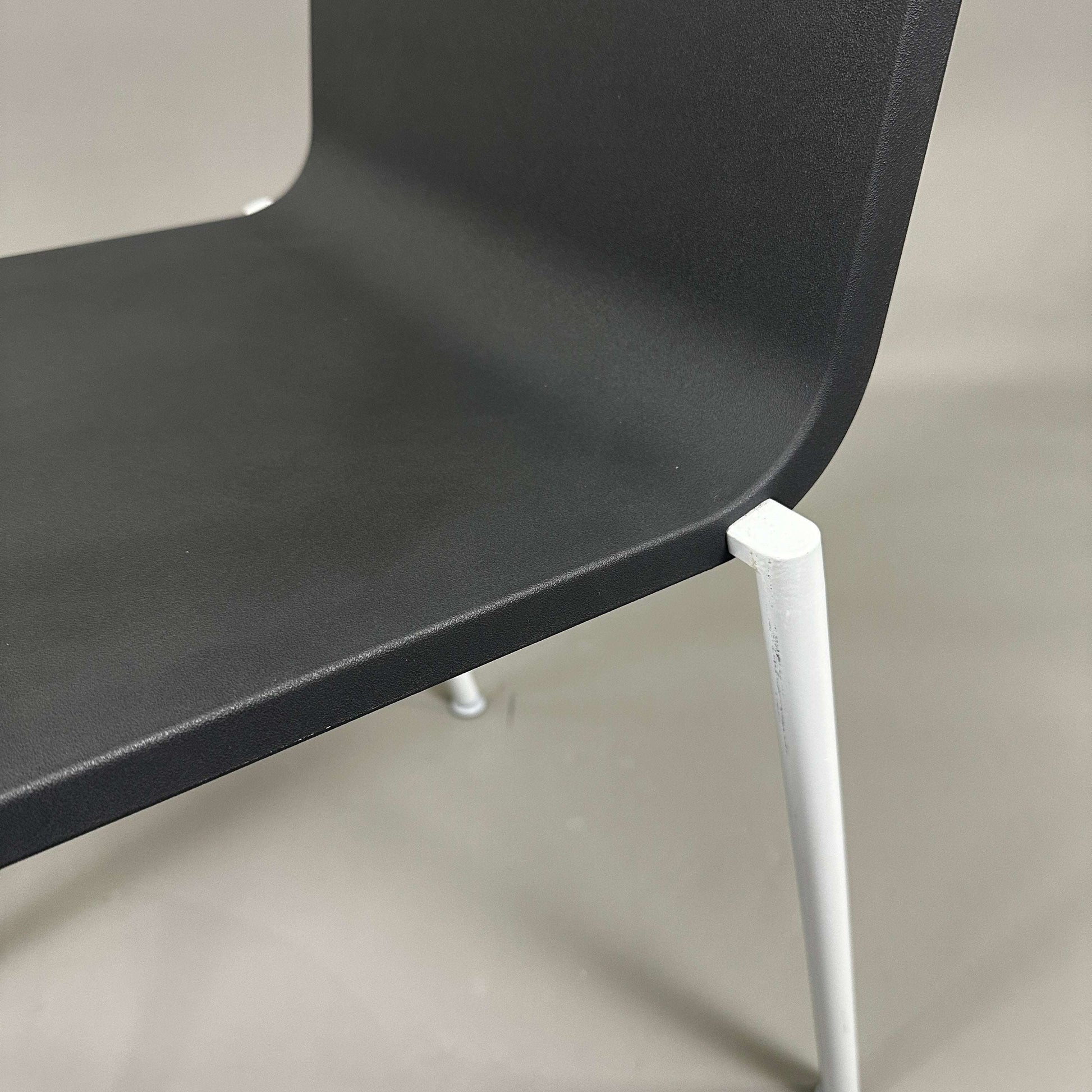 Close-up of black Vitra .03 Besucherstuhl with matte silver aluminum frame and plastic seat shell