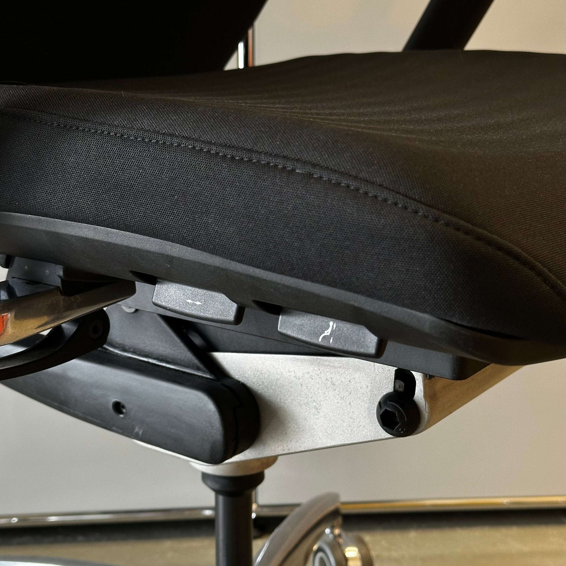 Close-up of black ergonomic padded seat of Wagner Titan 20 office chair with adjustable controls and headrest support
