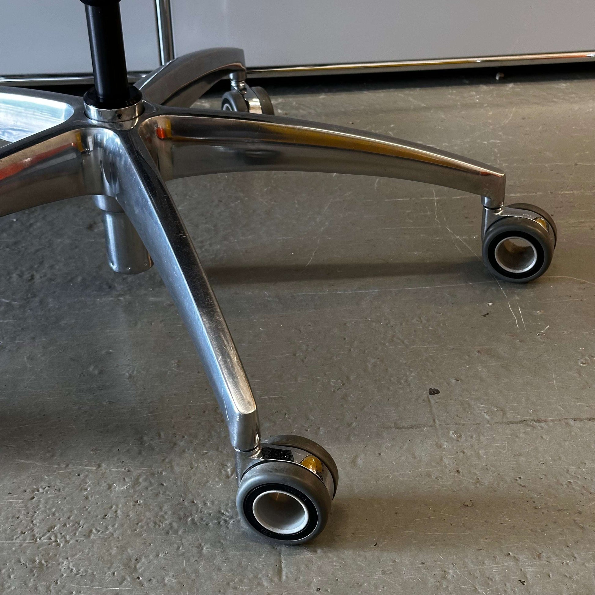 Close-up of Wagner Titan 20 black ergonomic office chair base with wheels and headrest
