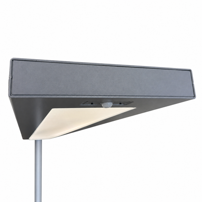 Silberne Waldmann Lavigo LED-Stehleuchte mit flachem Leuchtenkopf, integriertem Sensor und prismatischer Blende.