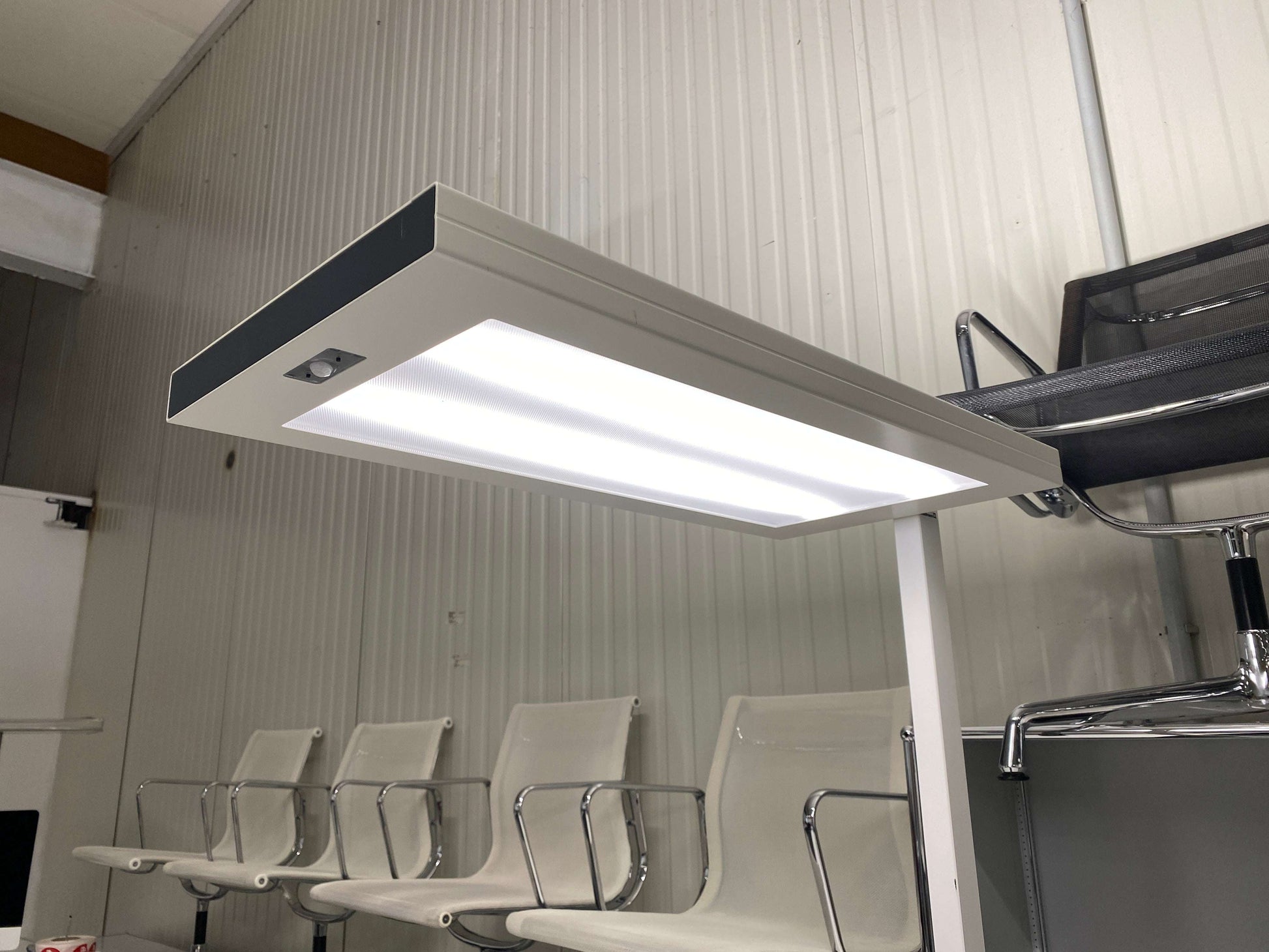 Waldmann Stehlampe LED floor lamp with separate upper and lower lights and sensor emitting 4000K pleasant light in office setting