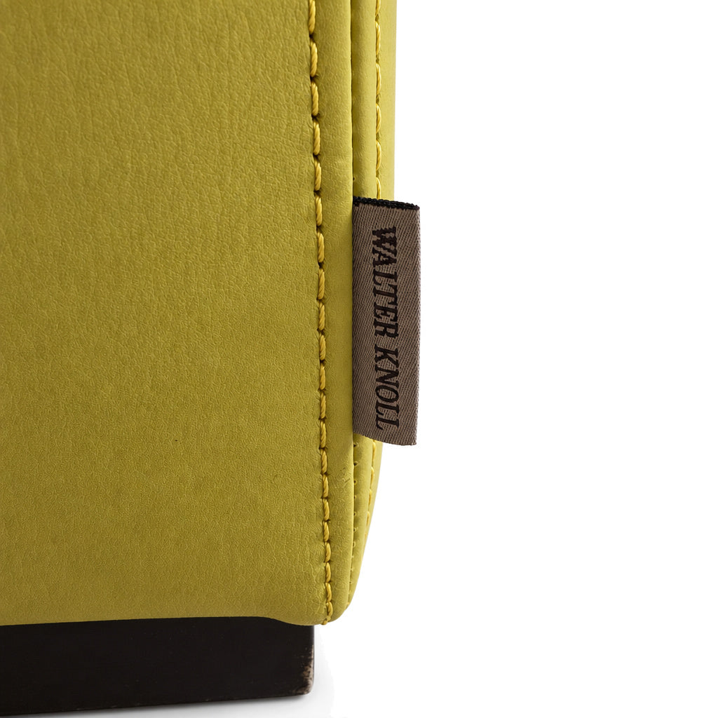Detailaufnahme eines gelb-grünen Walter Knoll Ledersessels mit markantem Markenlabel und hochwertigen Ziernähten.