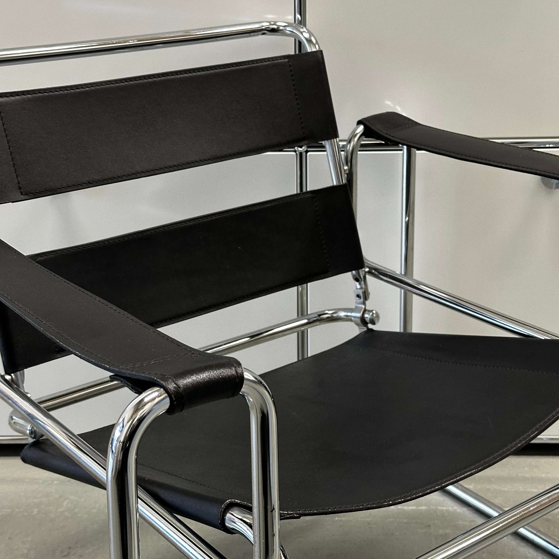 Black leather Wassily Knoll chair replica with chrome frame, modern and elegant design.