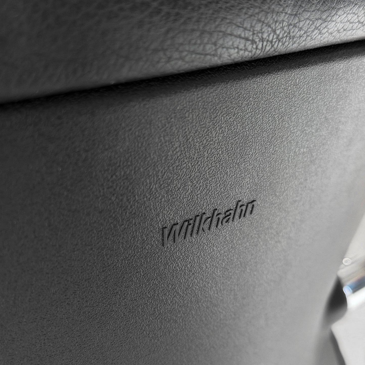 Nahaufnahme des Wilkhahn Logos auf dem schwarzen Leder Besprechungsstuhl Model 212/51.