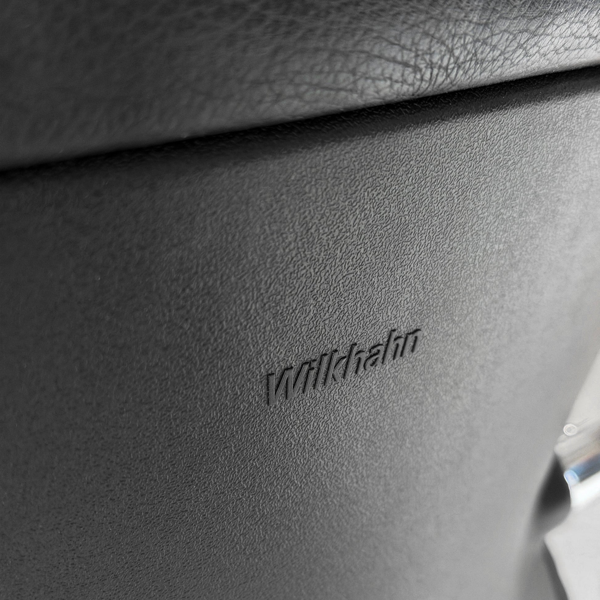 Nahaufnahme des Wilkhahn Logos auf dem schwarzen Leder Besprechungsstuhl Model 212/51.