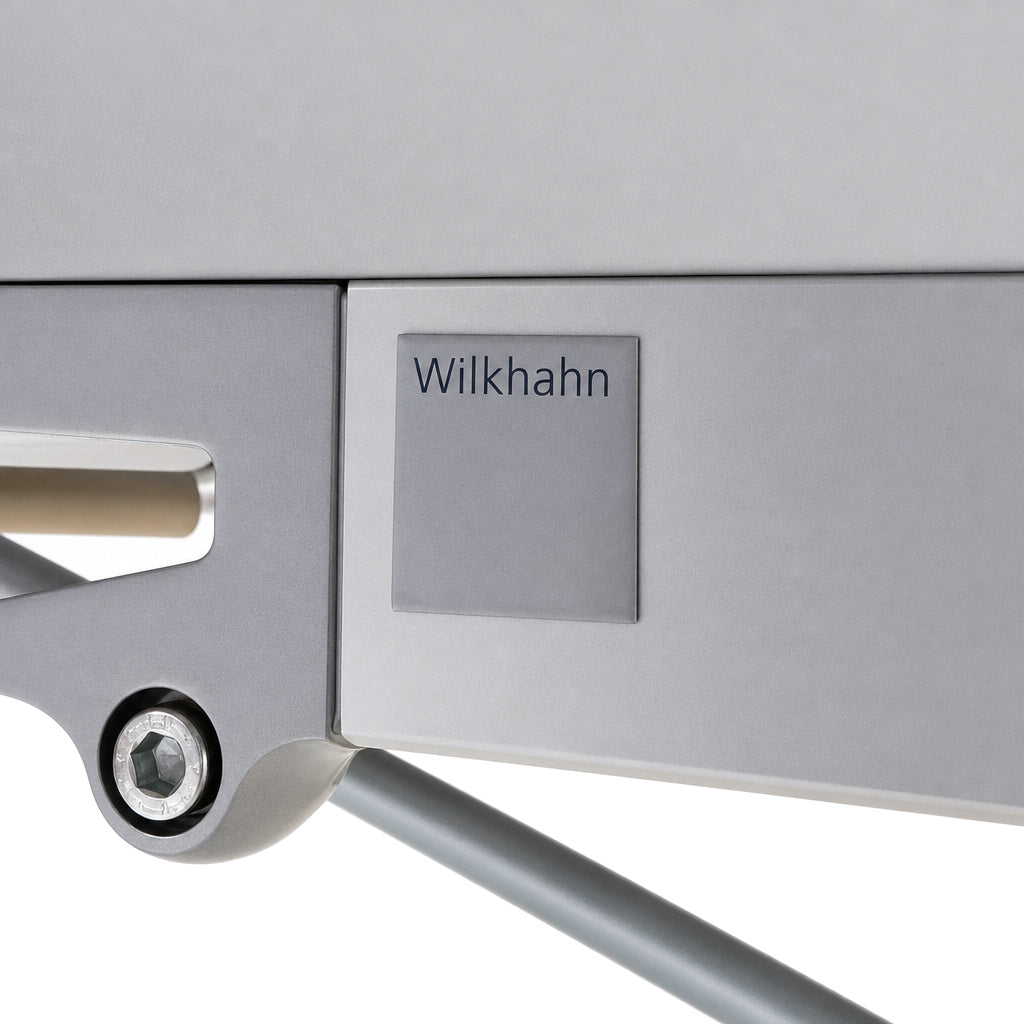Grauer Wilkhahn Confair Falttisch mit Metallrahmen, sichtbarem Logo-Emblem und hochwertiger technischer Konstruktion.