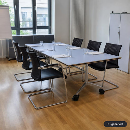 Wilkhahn Confair Falttisch 200x90cm mit hellgrauer Platte, silbernem Rollgestell und schwarzen Freischwinger-Bürostühlen.