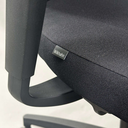 Close-up of Wilkhahn IN office chair seat with black fabric and plastic armrest
