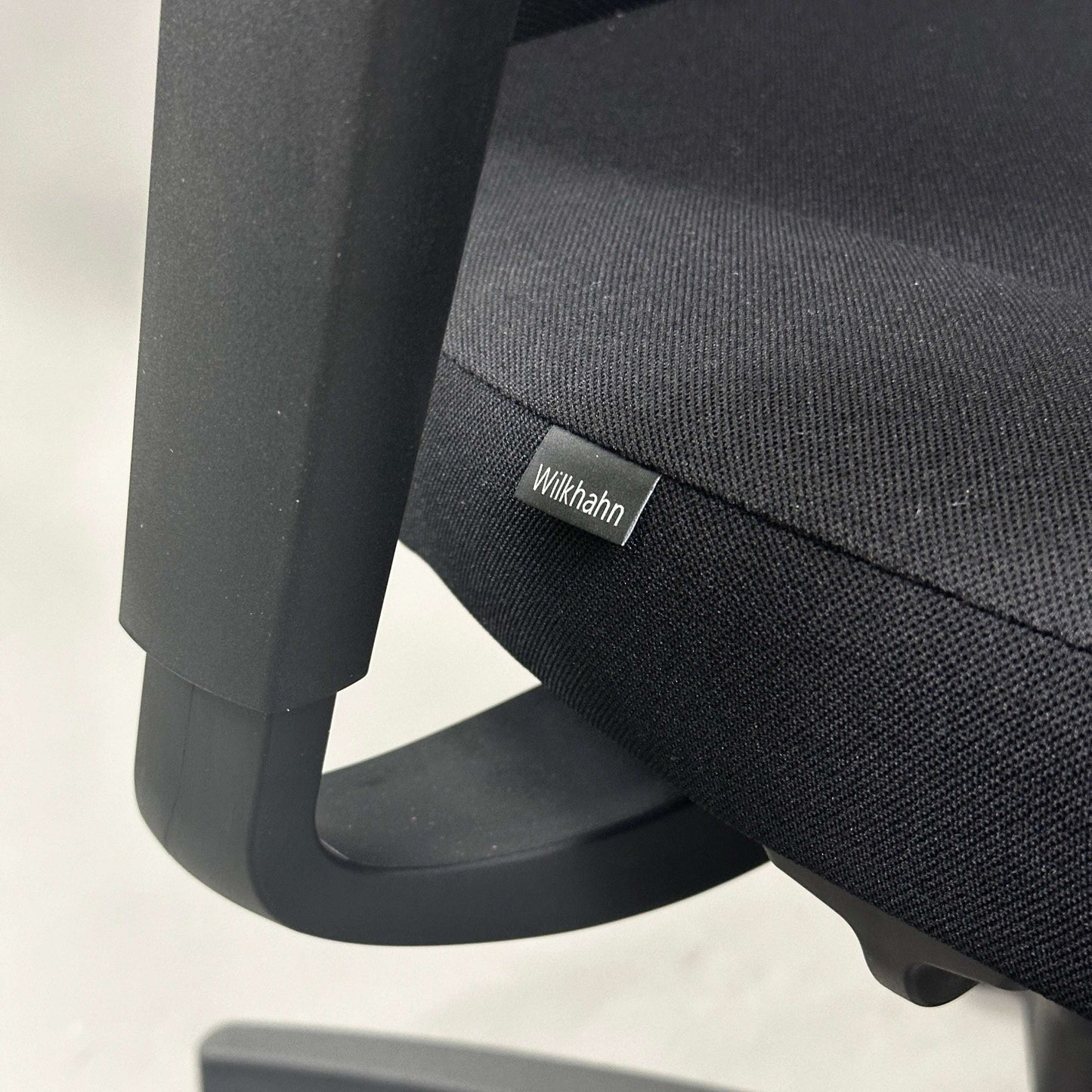 Close-up of Wilkhahn IN office chair with black fabric seat and adjustable armrest