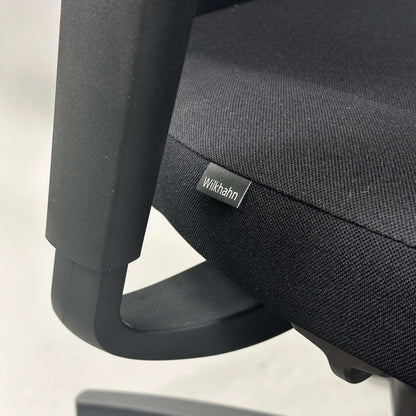 Close-up of Wilkhahn IN office chair with black fabric seat and adjustable armrest