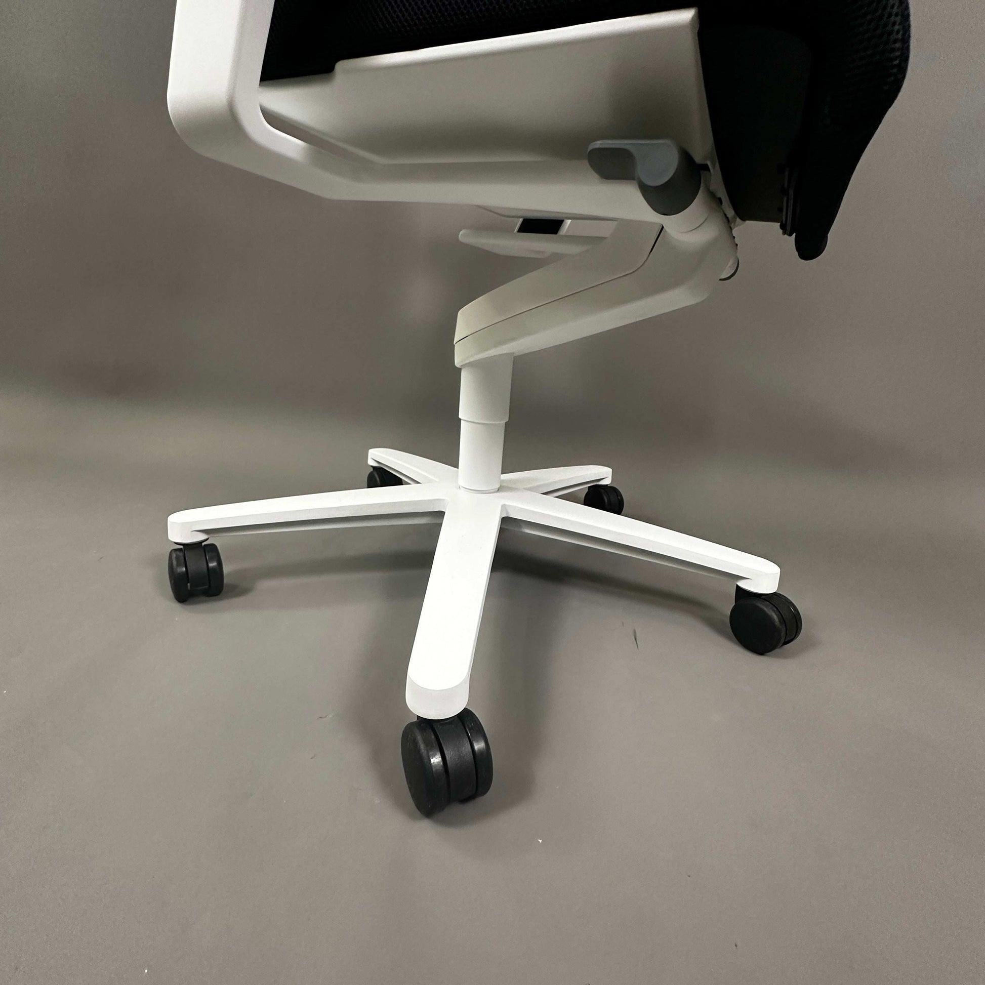 Wilkhahn ON office chair with white plastic base and universal black rollers on gray floor