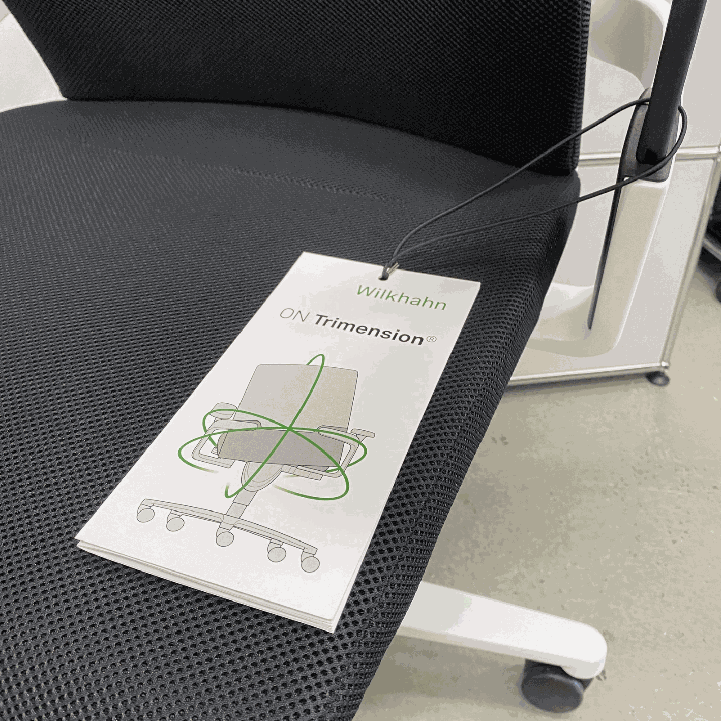 Wilkhahn ON office chair with black Fiberflex seat, white plastic base, universal casters, and ergonomic high back with headrest.