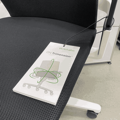 Wilkhahn ON office chair with black Fiberflex seat, white plastic base, universal casters, and ergonomic high back with headrest.