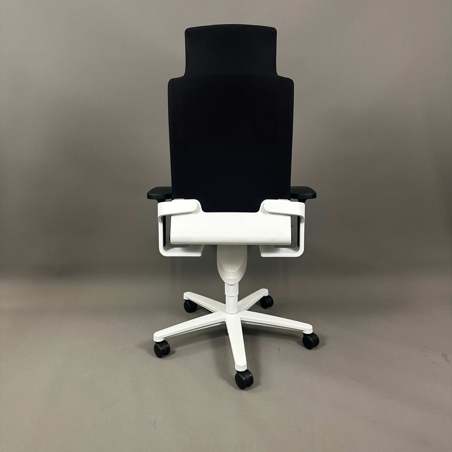 Wilkhahn ON high-back office chair with headrest, black Fiberflex upholstery, white plastic base, and universal casters.