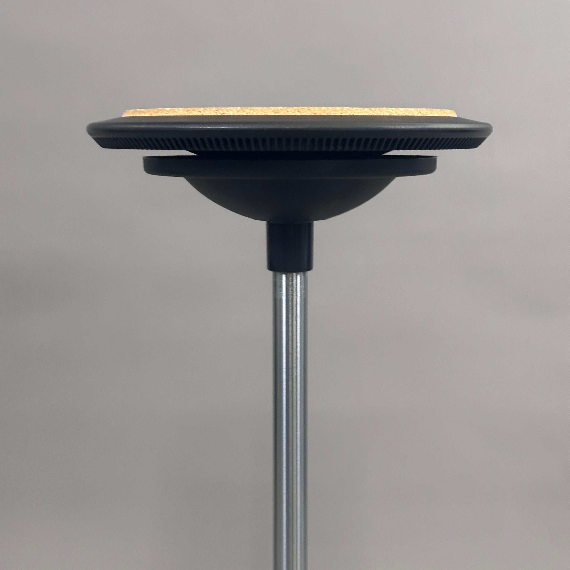Wilkhahn Stehhilfe Stitz with cork seat cushion and adjustable height stool against gray background