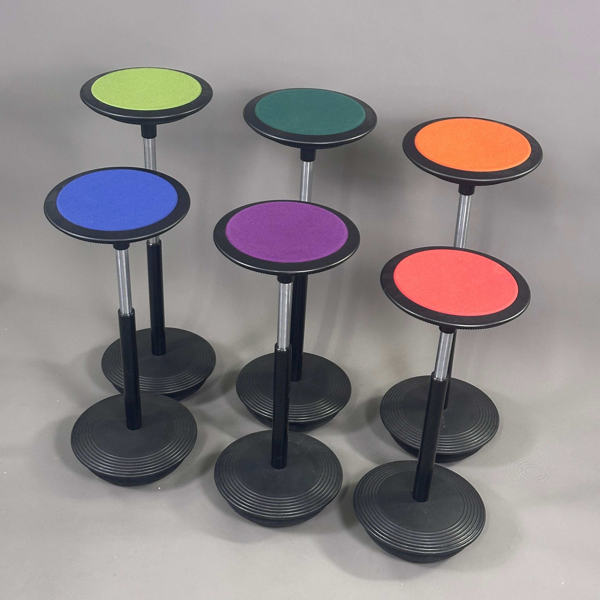 Wilkhahn Stehhilfe Stitz adjustable standing aid stools in various vibrant colors with round cushioned seats and black bases